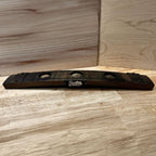 Wooden stave bitters display stand on a wooden surface.