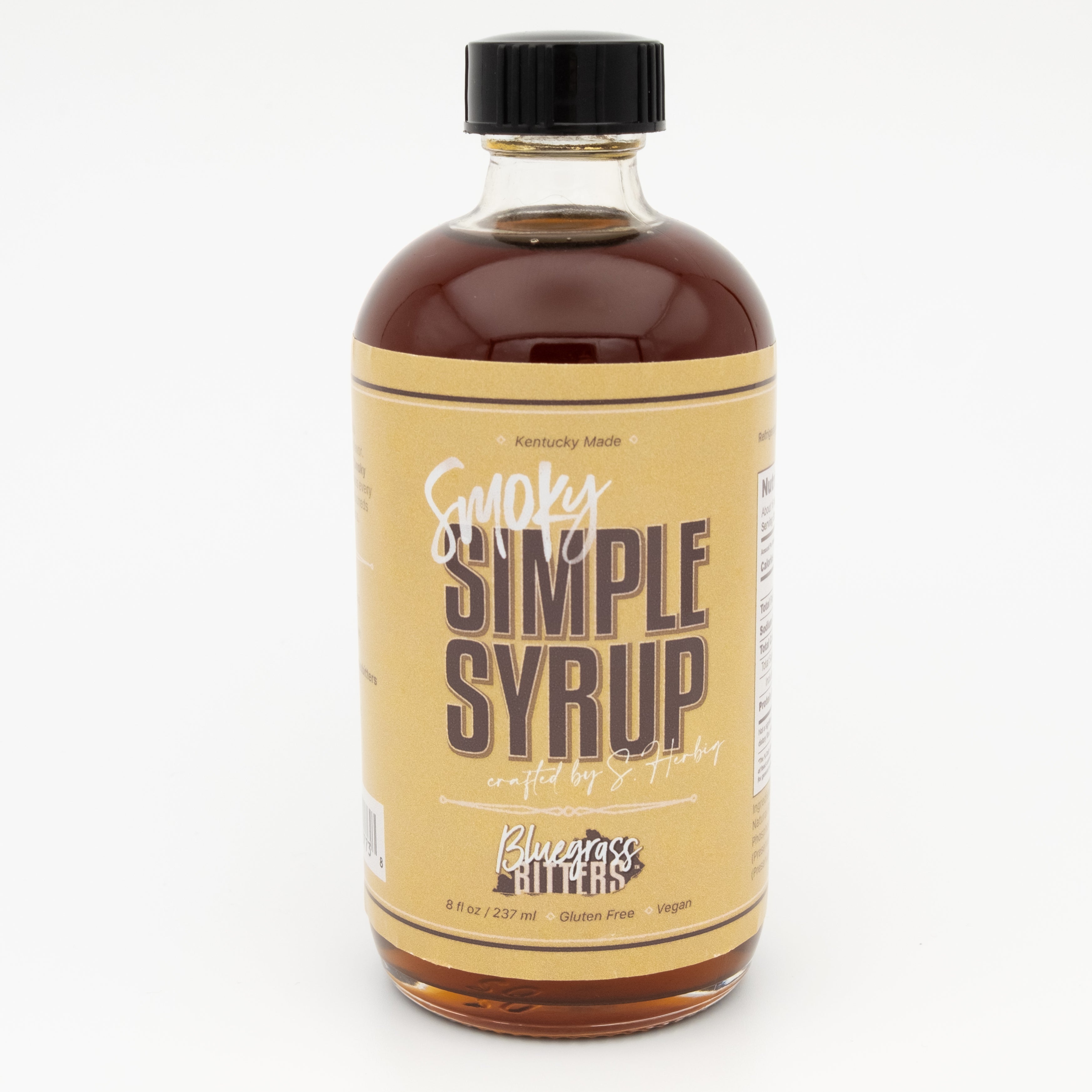 Bottle of Smoky Simple Syrup with a black cap on a white background