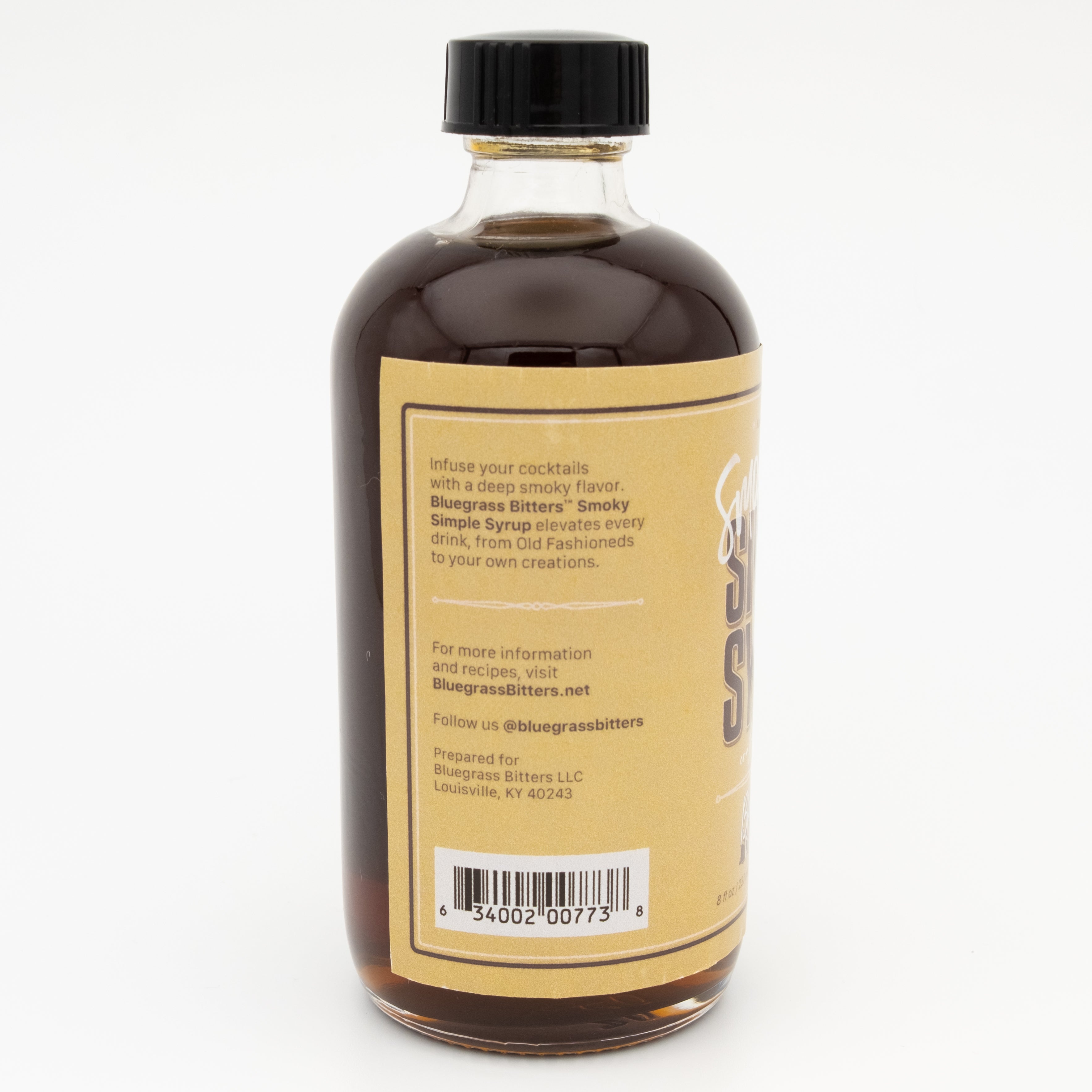 Bottle of Smoky Simple Syrup with a black cap on a white background